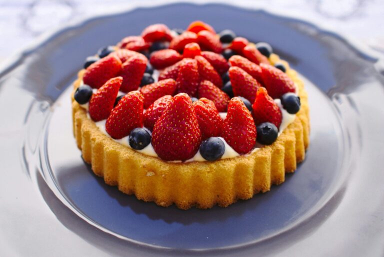 Scrumptious homemade fruit tart topped with fresh strawberries and blueberries.